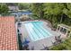 Community pool surrounded by lounge chairs, tables, and lush trees with a nearby playground at 8025 Georgetown Cir, Suwanee, GA 30024