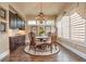Elegant dining area with a chandelier, wainscoting, and dark wood furnishings at 8025 Georgetown Cir, Suwanee, GA 30024
