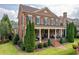 Classic brick home with a covered porch, manicured greenery, and symmetrical landscaping adding to its curb appeal at 8025 Georgetown Cir, Suwanee, GA 30024