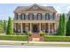 Brick home featuring a covered porch, black shutters and lush front yard landscaping at 8025 Georgetown Cir, Suwanee, GA 30024