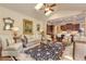 Open living space with a view of the kitchen, skylights, and dark patterned rug at 8025 Georgetown Cir, Suwanee, GA 30024