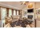 Comfortable living room with a fireplace, large windows, and hardwood floors at 8025 Georgetown Cir, Suwanee, GA 30024
