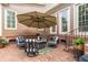 Cozy brick patio with outdoor seating around a fire pit and a large umbrella at 8025 Georgetown Cir, Suwanee, GA 30024