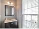 Stylish bathroom with a black vanity cabinet, bright counter, and a large mirror at 5362 Hickory Nw Knl, Norcross, GA 30071