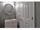 Cozy bathroom showcasing a vanity with sink, round mirror, and stylish fixtures at 5362 Hickory Nw Knl, Norcross, GA 30071