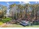 Aerial view showcasing waterfront property, dock, and lush greenery surrounding a beautiful lakeside home at 6475 Holland Dr, Cumming, GA 30041