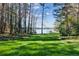 Sprawling green lawn leading to a tranquil lake and private dock surrounded by a scenic landscape at 6475 Holland Dr, Cumming, GA 30041