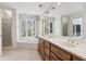 Bright bathroom with a soaking tub, double sinks, and a large window overlooking the backyard at 6475 Holland Dr, Cumming, GA 30041