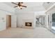 Bedroom with a fireplace, tray ceiling, and access to a deck via glass doors, offering comfort and style at 6475 Holland Dr, Cumming, GA 30041