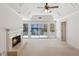 Bedroom featuring a fireplace, tray ceiling, and doors leading to the outdoor lake view at 6475 Holland Dr, Cumming, GA 30041