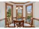 Bright breakfast nook with decorative windows, a chandelier, and a glass-top table with seating at 6475 Holland Dr, Cumming, GA 30041
