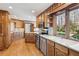 Spacious kitchen featuring wood cabinets, stainless steel appliances, and a large window with a scenic view at 6475 Holland Dr, Cumming, GA 30041