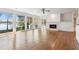 Bright living room featuring hardwood floors, fireplace, and lake views through large windows at 6475 Holland Dr, Cumming, GA 30041