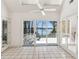 A sunroom with tile flooring, glass doors, and a ceiling fan, offering scenic lake views at 6475 Holland Dr, Cumming, GA 30041
