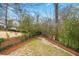 View of the backyard of the property with mature landscaping and a small section of green grass at 2413 Drew Valley Rd, Brookhaven, GA 30319