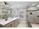 Modern bathroom with a double vanity, granite counters, and a glass-enclosed shower with stone accents at 2413 Drew Valley Rd, Brookhaven, GA 30319