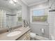 Bright bathroom with a single sink vanity, shower and tub combo, and a large mirror at 2413 Drew Valley Rd, Brookhaven, GA 30319