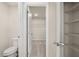 Bathroom featuring toilet, wire shelving, and doorway to closet space at 1084 Georgian Point Dr, Lawrenceville, GA 30045