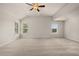 Spacious bedroom featuring plush carpet, a ceiling fan, and an abundance of natural light from large windows at 1084 Georgian Point Dr, Lawrenceville, GA 30045
