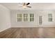 Spacious living room featuring wood-look floors, natural lighting, neutral paint, a ceiling fan, and backyard access at 1084 Georgian Point Dr, Lawrenceville, GA 30045