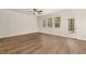 Cozy living room featuring wood-look floors, large windows, and a ceiling fan at 1084 Georgian Point Dr, Lawrenceville, GA 30045