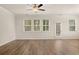 Bright living room with wood-look floors, large windows, and a ceiling fan at 1084 Georgian Point Dr, Lawrenceville, GA 30045