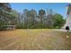 Expansive backyard featuring lush green grass and mature trees, offering privacy and a serene outdoor space at 12947 Dunand Blvd, Hampton, GA 30228