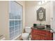 Stylish bathroom with stone vessel sink, ornate mirror, and window providing natural light at 12947 Dunand Blvd, Hampton, GA 30228