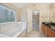 Bathroom featuring a tub with decorative window and granite countertop vanity with stylish fixtures at 12947 Dunand Blvd, Hampton, GA 30228