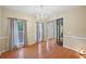 A dining room features hardwood floors, natural light, and a stylish chandelier at 12947 Dunand Blvd, Hampton, GA 30228