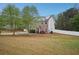 A charming exterior shot of a two-story brick home featuring solar panels and a spacious green lawn at 12947 Dunand Blvd, Hampton, GA 30228