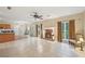 Spacious living room featuring a brick fireplace, ceiling fan and tile flooring at 12947 Dunand Blvd, Hampton, GA 30228