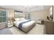 A spacious main bedroom with a large bed, sitting area, windows, and a stylish chandelier at 12947 Dunand Blvd, Hampton, GA 30228