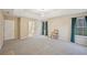 Large carpeted main bedroom with tray ceiling, stylish light fixture, and a doorway to an ensuite bath at 12947 Dunand Blvd, Hampton, GA 30228