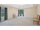 Spacious carpeted main bedroom featuring a tray ceiling, chandelier, large windows, and plenty of room at 12947 Dunand Blvd, Hampton, GA 30228