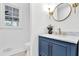 Powder room with a blue vanity, marble countertop, gold fixtures, and a round mirror at 2414 Cedar Wood Ct, Marietta, GA 30068