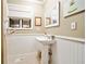 Elegant powder room with pedestal sink, wainscoting, and neutral decor at 2796 County Line Nw Rd, Acworth, GA 30101