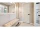 A hallway with neutral paint, a tufted bench, and access to a bathroom with a glass shower at 2796 County Line Nw Rd, Acworth, GA 30101