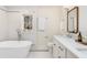 Bright bathroom featuring freestanding tub, undermount sink, wood framed mirror and patterned tile at 2818 Thornbriar Rd, Atlanta, GA 30340