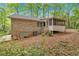 View of the backyard featuring the back of the house with a screened-in porch and natural surroundings at 8980 Country Club Dr, Douglasville, GA 30134