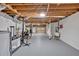 Unfinished basement with gray painted floors and a wooden ceiling, leading to a garage at 8980 Country Club Dr, Douglasville, GA 30134