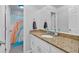 Bright bathroom with granite countertops and a rainbow shower curtain, adding a playful splash of color at 8980 Country Club Dr, Douglasville, GA 30134