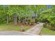 View of brick home with long driveway, landscaping, and mature trees at 8980 Country Club Dr, Douglasville, GA 30134