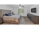 Bright main bedroom featuring a ceiling fan, plush bed, and a window overlooking the front yard at 8980 Country Club Dr, Douglasville, GA 30134
