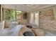 Relaxing screened porch with brick wall, patio furniture, and view to the outdoor scenery at 8980 Country Club Dr, Douglasville, GA 30134