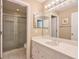 Bright bathroom featuring a large mirror, vanity with sink, and a glass-enclosed shower at 3994 Columns Dr, Marietta, GA 30067