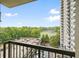 A scenic balcony view overlooking the parking area, sports field, and lush trees, with a clear blue sky above at 795 Hammond Dr # 709, Atlanta, GA 30328