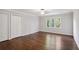 Bright bedroom featuring hardwood floors, natural light, and double door closets at 8900 River Trace Dr, Johns Creek, GA 30097