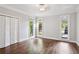 Spacious bedroom with hardwood floors, three bright windows, and a double-door closet at 8900 River Trace Dr, Johns Creek, GA 30097