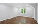 Empty bedroom with hard wood floors and a window letting in plenty of natural light at 8900 River Trace Dr, Johns Creek, GA 30097